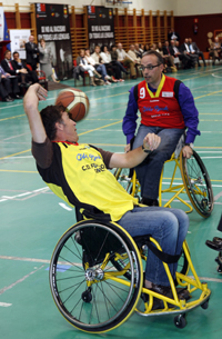 Pedro Delgado y Alfredo Urdaci se disputan un balón durante la exhibición de baloncesto en silla de ruedas