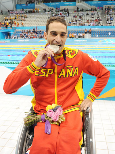 Miguel Luque mordiendo su medalla de plata