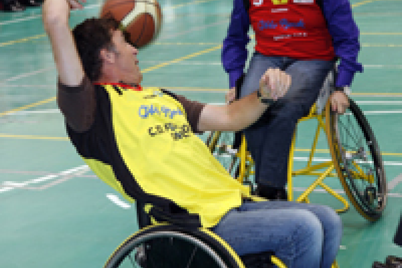 Pedro Delgado y Alfredo Urdaci se disputan un bal&#243;n durante la exhibici&#243;n de baloncesto en silla de ruedas